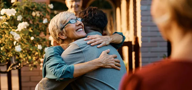 Happy senior woman embraces her son